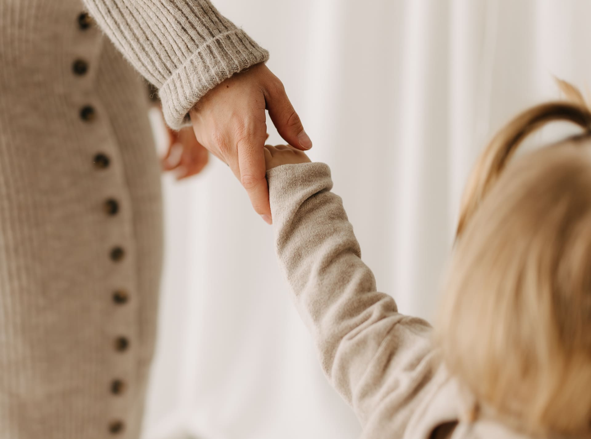 Mama hält die Hand ihres Kindes — der Moment, den man festhalten will