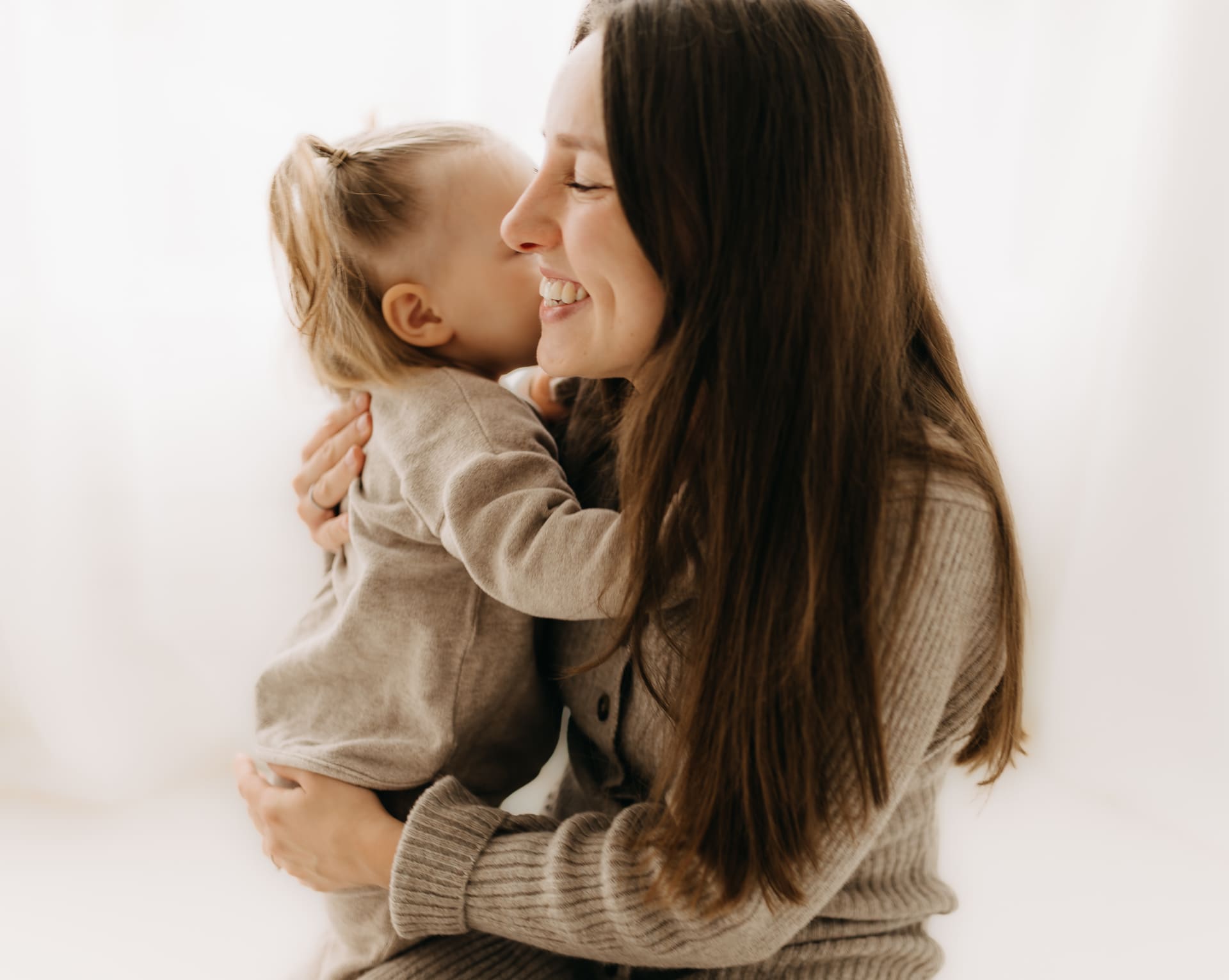 Mama umarmt ihr Kind herzlich — authentisches Familien-Shooting im Tageslichtstudio Bottrop
