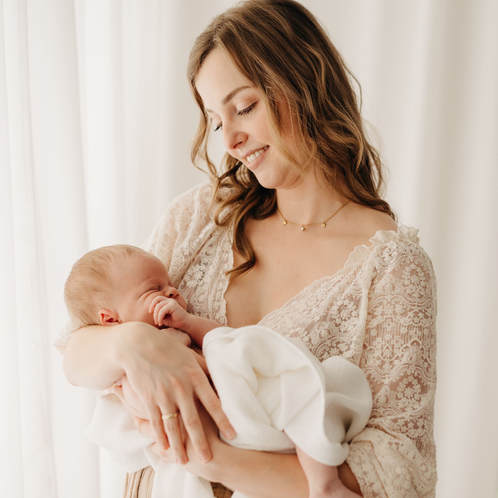 Mama hält ihr schlafendes Neugeborenes — Newborn-Fotografie im Tageslichtstudio Bottrop