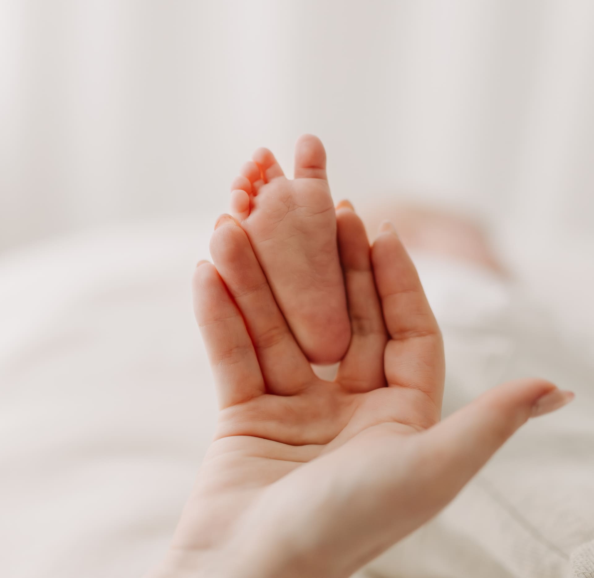 Babyfuß liegt in Mamas offener Hand — Detailaufnahme Newborn-Shooting Bottrop