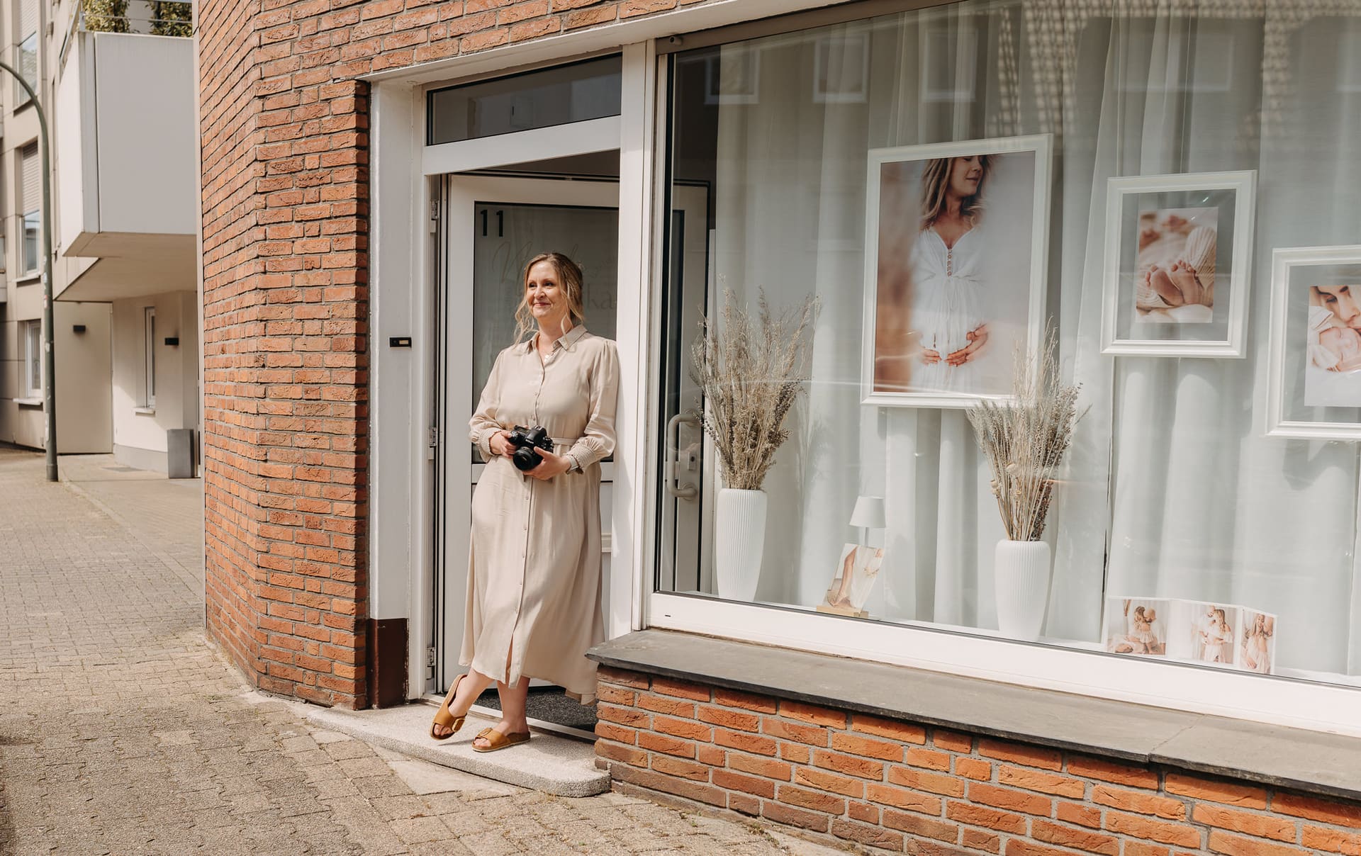 Nicole Averkamp steht vor dem Eingang ihres Tageslichtstudios in Bottrop, Kamera in der Hand