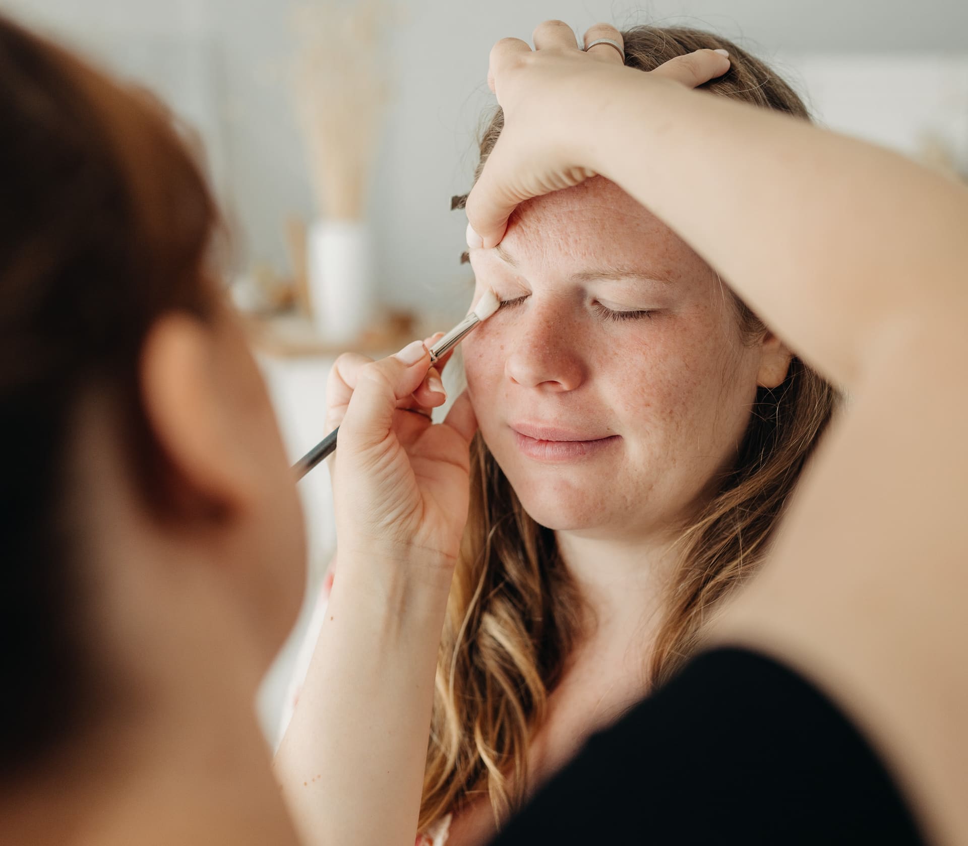 Mama wird vor dem Shooting professionell geschminkt — Styling-Service im Tageslichtstudio Bottrop