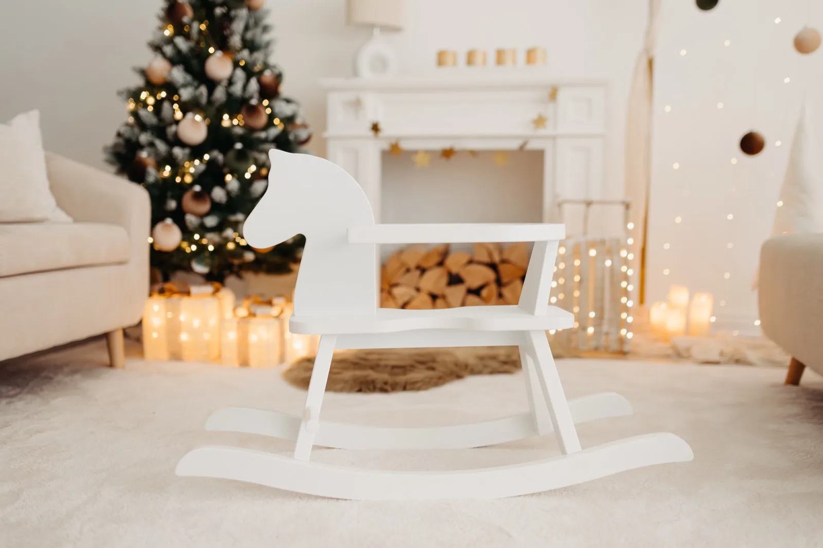Weißes Schaukelpferd vor dem geschmückten Weihnachtsbaum und Kamin in der Studiokulisse — Weihnachts-Mini-Shootings bei Nicole Averkamp Fotografie in Bottrop