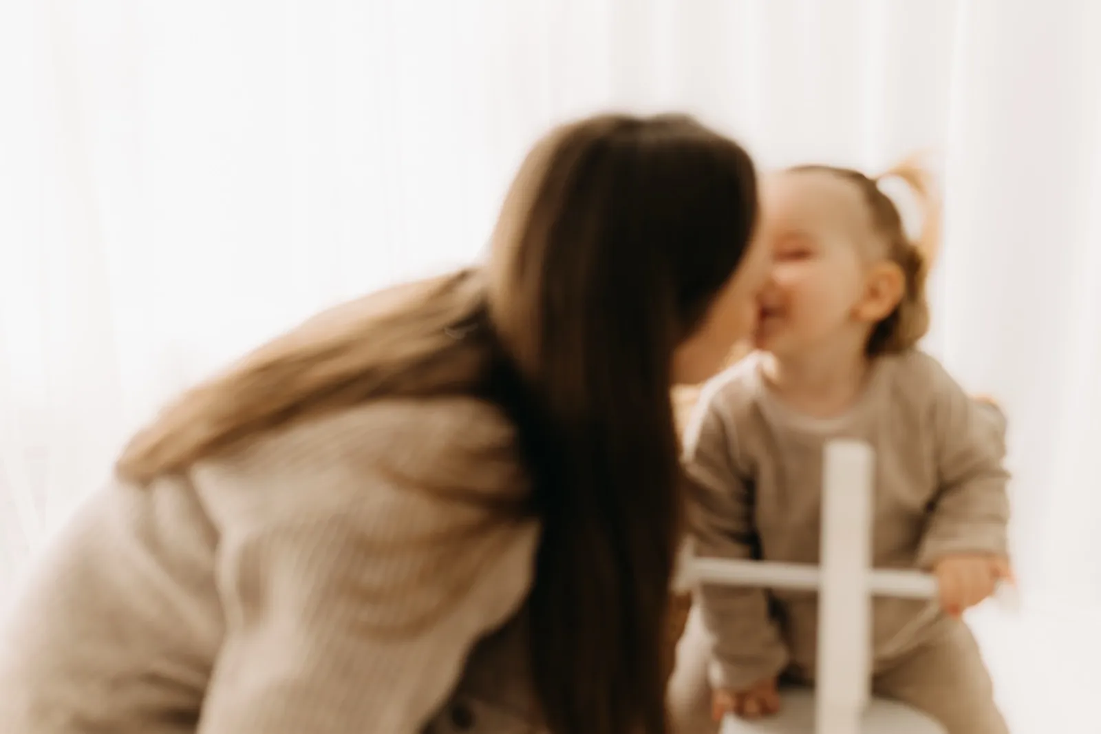 Mama gibt ihrer Tochter einen Kuss auf die Wange